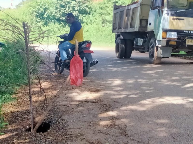 Warga memperlihatkan lubang yang tepat berada di bahu jalan lingkar kompleks Perkantoran Abdya jalan Bukit Hijau, Keude Paya