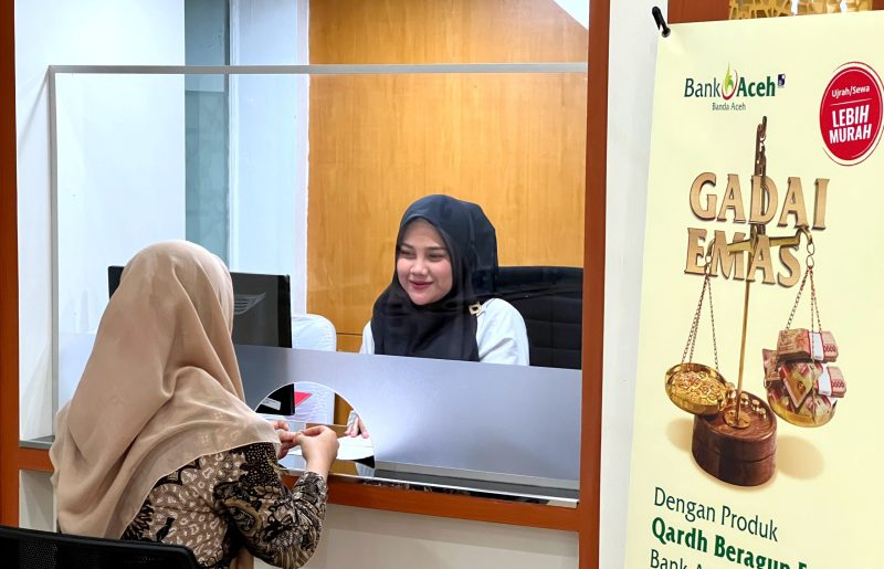 Petugas Gadai Emas Bank Aceh tengah melayani nasabah dalam transaksi Kejar Promo (Kepo) Gadai Emas, Banda Aceh, Rabu (4/01/2023). Promo Kepo Gadai Emas menggratiskan biaya administrasi serta menyediakan souvenir menarik.