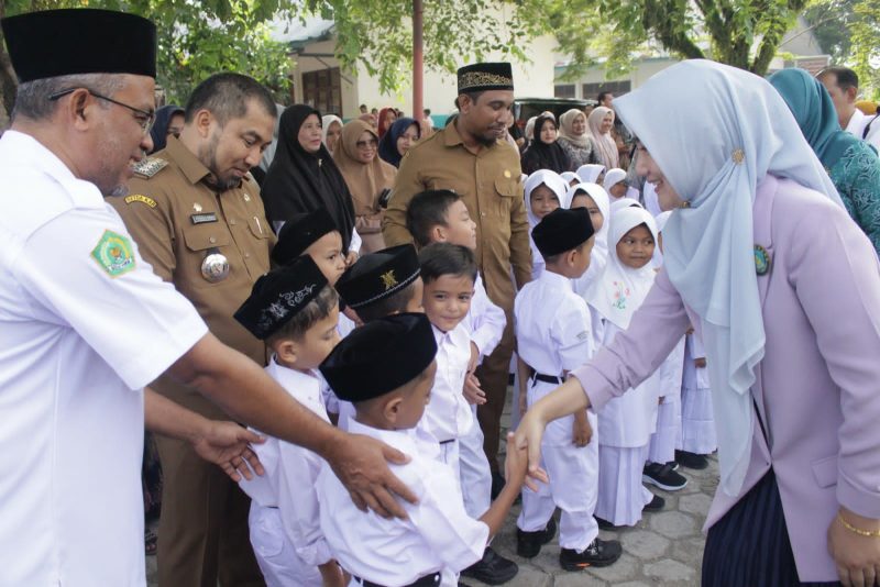 Pj Bupati Aceh Besar Muhammad Iswanto SSTP MM bersama Bunda PAUD Aceh Besar Cut Rezky Handayani SIP MM, mendampingi Bunda PAUD Aceh Ny Ayu Marzuki dan Ketua DWP Aceh Mellani Subarni, saat meninjau penerapan masa perkenalan sekolah bagi peserta didik pada hari pertama masuk sekolah, di MIN 5 Aceh Besar, Sibreh, Kecamatan Suka Makmur, Senin (17/7/2023).