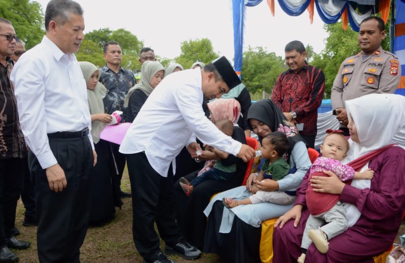 Pj Bupati Aceh Besar, Muhammad Iswanto SSTP MM memberikan minuman penambah gizi kepada anak balita dalam acara Launching kegiatan USK terkait penanganan stunting sebagai bagian dari penelitian profesor berkarya di Gampong Lamtanjong, Kecamatan Suka Makmur, Sibreh, Aceh Besar, Jumat (22/09/2023).