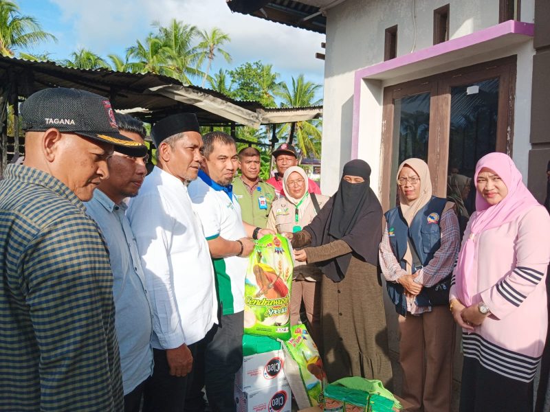 Pj Bupati Aceh Besar, Muhammad Iswanto, di dampingi Plt Kadinsos Aceh Besar, Aulia Rahman, saat 
menyerahkan bantuan masa panik kepada warga tertimpa musibah. Foto: Noa.co.id/Nazarullah
