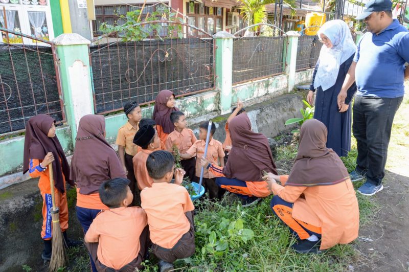 Sekdakab Aceh Besar, Drs Sulaimi MSi bersama istri berdialog dengan murid sekolah dalam kegiatan aksi 1 jam memingut sampah dalam memperingati Hari Guru Nasional Tahun 2023 di Sekolah Dasar Negeri (SDN) Lemreung, Kecamatan Kreung Barona Jaya, Aceh Besar, Sabtu (25/11/2023).