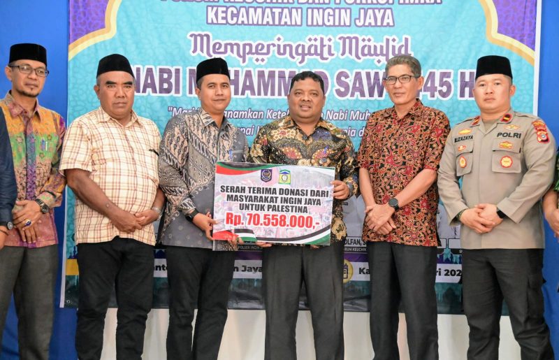 Sekdakab Aceh Besar, Drs Sulaimi MSi dan Camat Ingin Jaya, Al Mubarak AKbar, S.STP foto bersama seusai menyerahkan Donasi dari masyarakat Ingin Jaya untuk Palestina di Aula Kantor Camat Ingin Jaya, Aceh Besar, Kmis (04/01/2024).