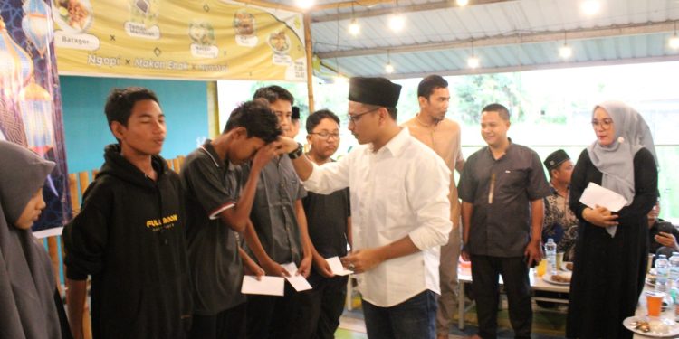 Ketua Panwaslih Abdya menyerahkan santunan kepada anak yatim. Foto Teuku Nizar