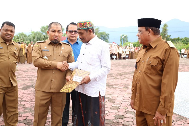 Pj Bupati Aceh Besar Muhammad Iswanto SSTP MM menyerahkan Surat Keputusan Pengakuan dan Perlindungan Masyarakat Hukum Adat kepada perwakilan imuem mukim di halaman Kantor Bupati Aceh Besar, Kota Jantho, Senin (3/6/2024). Foto: Hidayat S/NOA.co.id