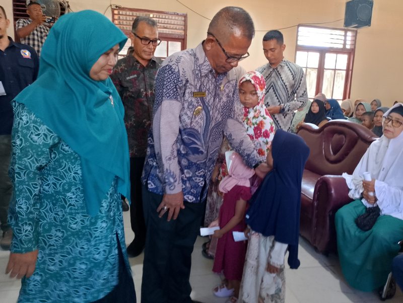 Pj, Bupati Pidie Jaya Ir. Jailani Beuramat di dampingi  Istri Nurbaiti Jalinai menyerahkan santunan kepada Anak Yatim piatu secara simbolis, Meureudu, Aula Kantor Camat Meureudu, Kamis (13/6/2024), ( Foto|Muhammad Rissan/NOA.co.id)