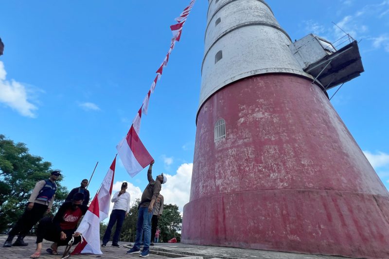 Kepala Badan Kesbangpol Aceh, Dedy Yuswadi bersama Kabid Bina Ideologi, Wawasan Kebangsaan Dan Karakter Bangsa, Munarwansyah mengibarkan Bendera Merah Putih di Mercusuar Willem's Torrent III, Pulo Breuh, Aceh Besar, Sabtu 6 Juli 2024. Foto: Biro  Adpim Setda Aceh. 