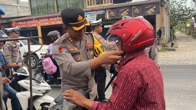 Kapolres Aceh Utara AKBP Nanang Indra Bakti (Kedua Kanan) saat memakai helem gratis pada pengguna jalan pada Operasi Patuh Seulawah 2024, Rabu, (24/7/2024) (Foto Zubir.noa.co.id).