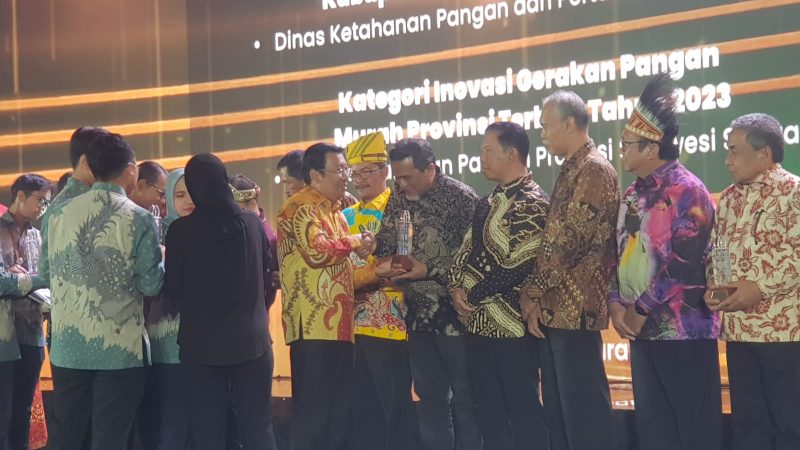 Plt Kadis Pangan, Aceh Barat Kamarlis, saat menerima penghargaan Bapanas Award yang diserahkan langsung oleh Kepala BAPANASl RI, Arief Prasetyo Adi dalam kategori Kabupaten Pengendali Inflasi. Foto: dok. Humas Diskominsa Aceh Barat