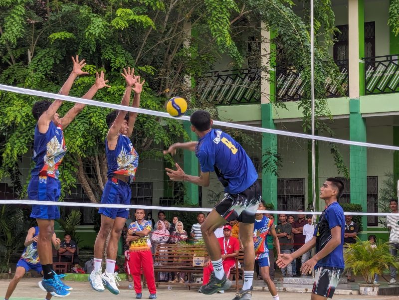 Para pemain volly Pidie berkustum biru-biru saat memblok smes anak-anak Kota Lhokseumawe pada laga semifinal Popda Aceh XVII di lapangan SMA Negeri I IDI Aceh Timur, Rabu, (10/7/2024). Foto: dok. Amir Sagita/NOA.co.id