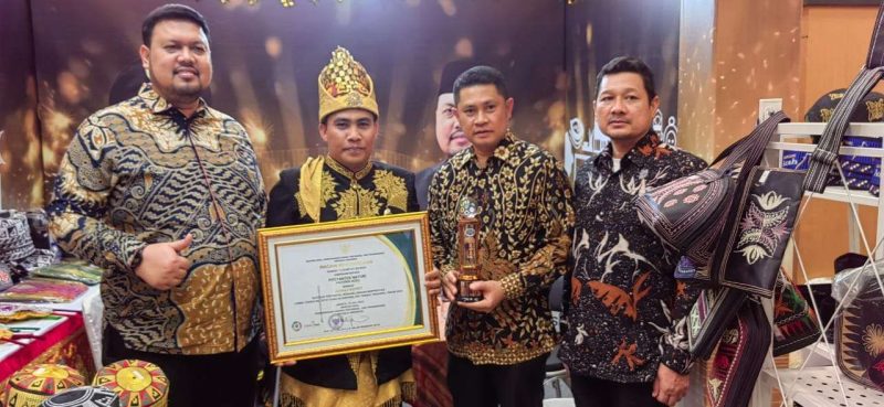 Ketua Posyantek Naturi, Faisal didampingi Kepala DPMG Provinsi Aceh usai menerima Piala Juara Favorit Nasional pada Lomba Teknologi Tepat Guna Nasional (TTGN) ke-25 di Lapangan Islamic Center Mataram, Nusa Tenggara Barat (NTB), Senin (15/7/2024). FOTO: DPMG Aceh Besar/NOA.co.id