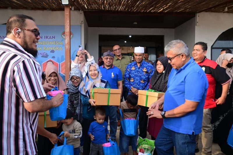 Kepala DPPKBPP dan PA Aceh Besar Drs. Fadhlan mendampingi Pj Gubernur Aceh Bustami Hamzah SE. M.Si membagikan ikan segar kepada ibu hamil di Moon Beach Cafe, Pulau Kapuk, Kecamatan Lhoknga, Aceh Besar, Selasa (23/7/2024). Foto/MC Aceh Besar.