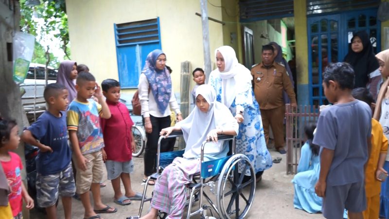 Pj Ketua Tim Penggerak PKK Aceh Mellani Subarni saat mengantar kursi roda sekaligus memberikan santunan untuk Asmaul Husna (27) yang menderita lumpuh selama delapan bulan terakhir, di Gampong Ceurieh Cot, Kecamatan Delima, Kabupaten Pidie, pada Senin (19/8/2024). Foto: Humas Aceh