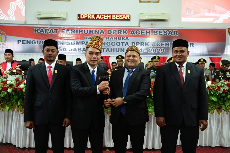 Ketua DPRK Terdahulu Iskandar Ali menyerahkan Palu Sidang kepada Ketua DPRK Aceh Besar sementara Abdul Muchti dalam Sidang Paripurna di Kota Jantho, Selasa (20/08/2024). Foto: MC Aceh Besar