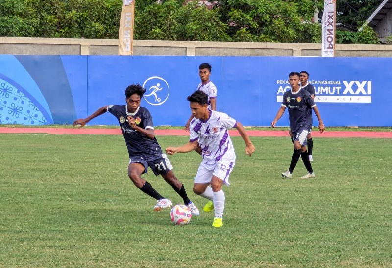 Pemain Gorontalo memakai kustum warna putih dibayang-bayangi pemain NTT saat menggiring bola pada laga pamungkas PON Aceh-Sumut di Stadion Blang Paseeh, Kota Sigli, Kabupaten Pidie, Senin (9/9/2024) (Foto Amir Sagita.NOA.co.id).