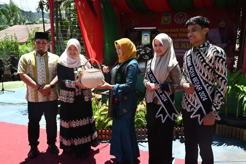 Pj Bupati Aceh Besar Muhammad Iswanto SSTP MM bersama Pj Ketua PKK Aceh Besar Cut Rezky Handayani SIP MM menyerahkan bingkisan kepada Pj Ketua Dekranasda Aceh Safriati dalam acara Pembinaan dan Penilaian Desa Kerajinan Tahun 2024 di Meunasah Gampong Kueh, Kecamatan Lhoknga, Aceh Besar, Kamis (10/10/2024). Foto: MC Aceh Besar