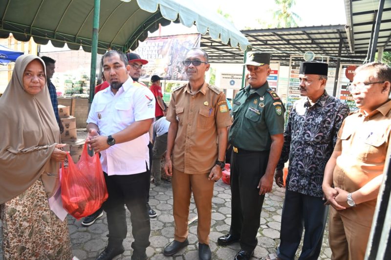 Pj Bupati Aceh Besar Muhammad  Iswanto SSTP MM didampingi Kadis Pangan Aceh Besar Alyadi SPi MM  dan Forkopimcam Kuta Baro menyerahkan secara simbolis sembako kepada masyarakat di pasar murah yang digelar Pemkab Aceh Besar dan Perum Bulog Kanwil Aceh di Halaman Meunasah Gampong Beung Bak Jok, Kecamatan Kuta Baro, Aceh Besar, Selasa (29/10/2024). Foto: MC Aceh Besar