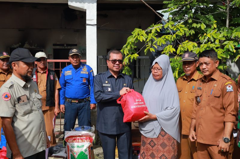 Pj Bupati Aceh Barat saat menyerahkan Bantuan Masa Panik kepada Korban Kebakaran. Foto: dok. Diskominsa Aceh Barat