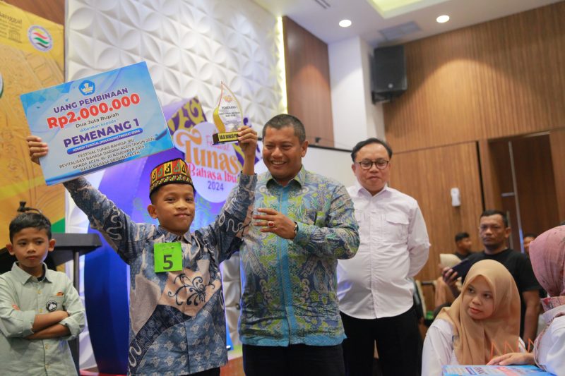 Kadisdikbud Aceh Besar Bahrul Jamil S.Sos, M.Si, meyerahkan hadiah kepada para juara pertama tingkat SD pada penutupan FTBI Tingkat Provinsi Aceh Tahun 2024, di Hotel Ayani, Kota Banda Aceh, Selasa (19/11/2024) malam. Foto: dok. MC Aceh Besar