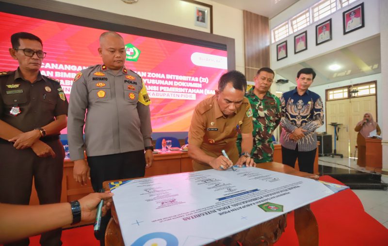 Pj Bupati Pidie, Drs Samsul Azhar, saat menandatangani ZI dan Bimbingan Teknis Penyusunan Dokumen Sistem Akuntabilitas Kinerja Instansi Pemerintah (SAKIP) pada Unit Kerja Dilingkungan Pemerintah Kabupaten Pidie, Senin (26/11/2024) du Oproom Setdakab Pidie, (Foto.DOK Humas,NOA.co.id). 
