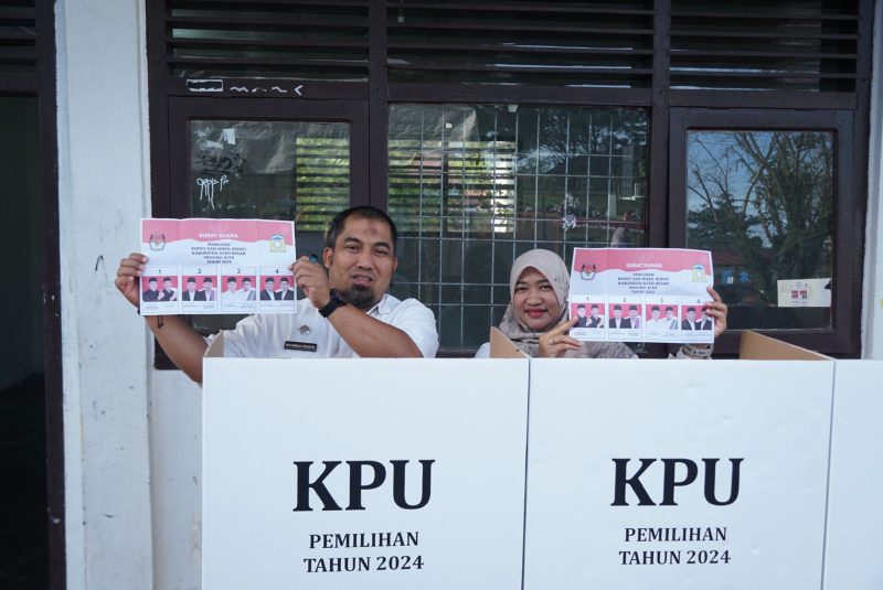 Pj Bupati Aceh Besar Muhammad Iswanto SSTP MM dan keluarga foto bersama perabgkat gampong usai menyalurkan hak pilihannya pada Pilkada Aceh Besar tahun 2024 di Tempat Pemungutan Suara (TPS) 001 Jantho Makmur, Kota Jantho, Rabu (27/11/2024). Foto: dok. MC Aceh Besar